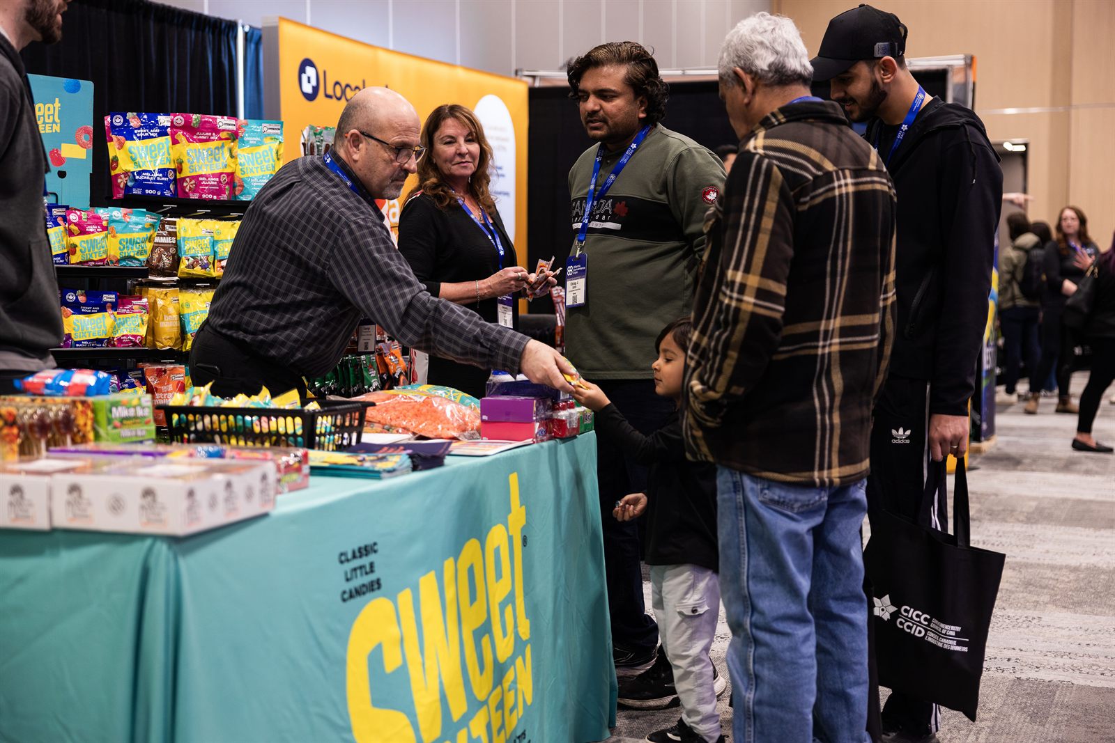 Buyers sampling products at an exhibitor booth on the ACE show floor