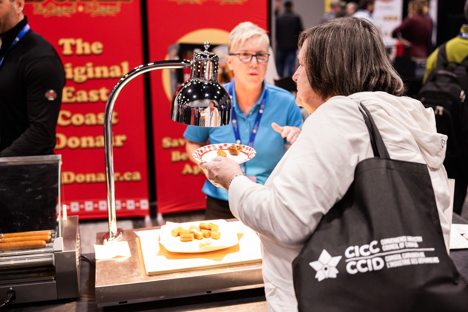 An exhibitor serving samples to a buyer at the ACE show floor